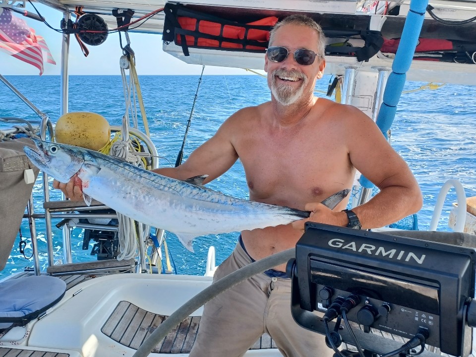 Lee, a man, in a boat holding a fish